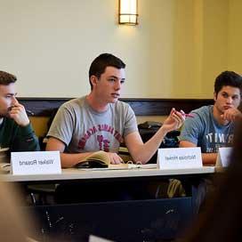 A student makes a point during a seminar class discussion